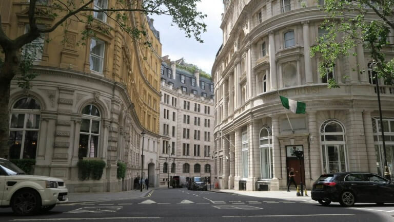 view of an elegant, curved London intersection featuring grand, multi-story stone buildings with neoclassical architecture